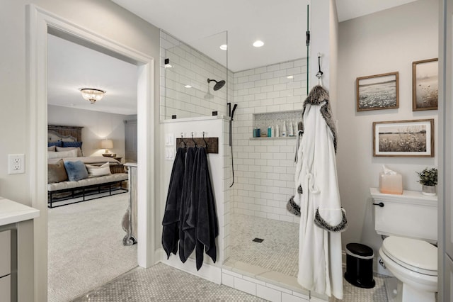 bathroom featuring tiled shower, toilet, and tile patterned flooring