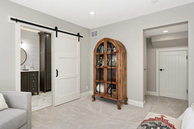 living area featuring light colored carpet and a barn door