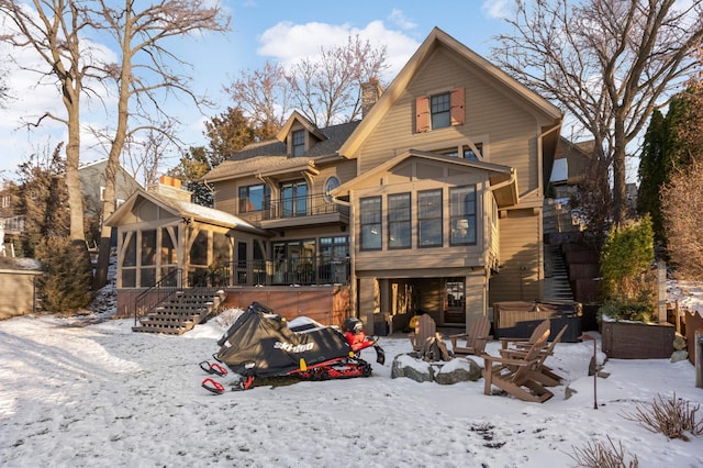 snow covered property featuring a hot tub and a sunroom