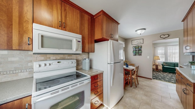 kitchen featuring light tile patterned flooring, white appliances, and backsplash