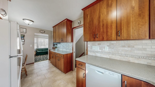 kitchen with tasteful backsplash, light tile patterned flooring, and white appliances