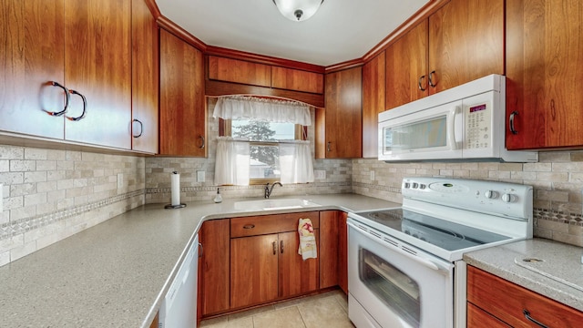 kitchen featuring tasteful backsplash, light tile patterned flooring, sink, and white appliances