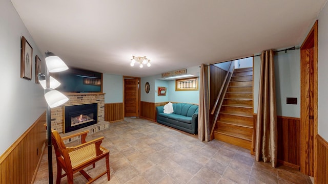 living room featuring a fireplace and wooden walls