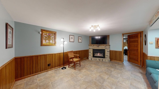 living area with a brick fireplace and wooden walls