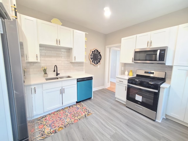 kitchen featuring white cabinetry, stainless steel appliances, sink, and light hardwood / wood-style flooring