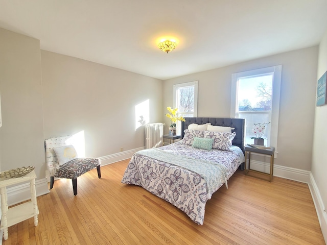 bedroom featuring radiator and light hardwood / wood-style floors