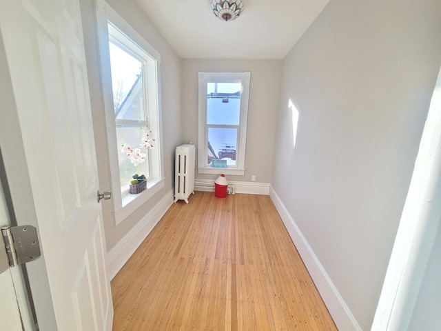 interior space featuring radiator heating unit and light hardwood / wood-style floors