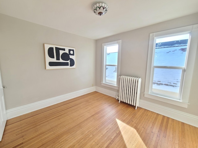 spare room with light hardwood / wood-style flooring and radiator heating unit