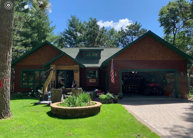 view of front of property featuring decorative driveway, an attached garage, and a front yard