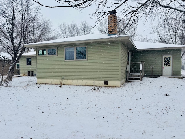 view of snow covered back of property