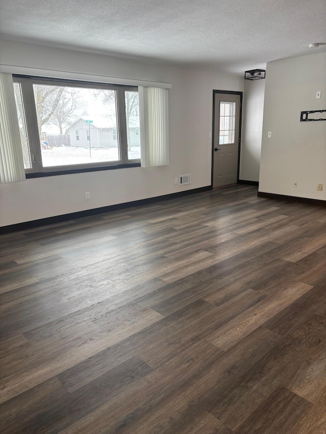 unfurnished room featuring dark hardwood / wood-style floors and a textured ceiling