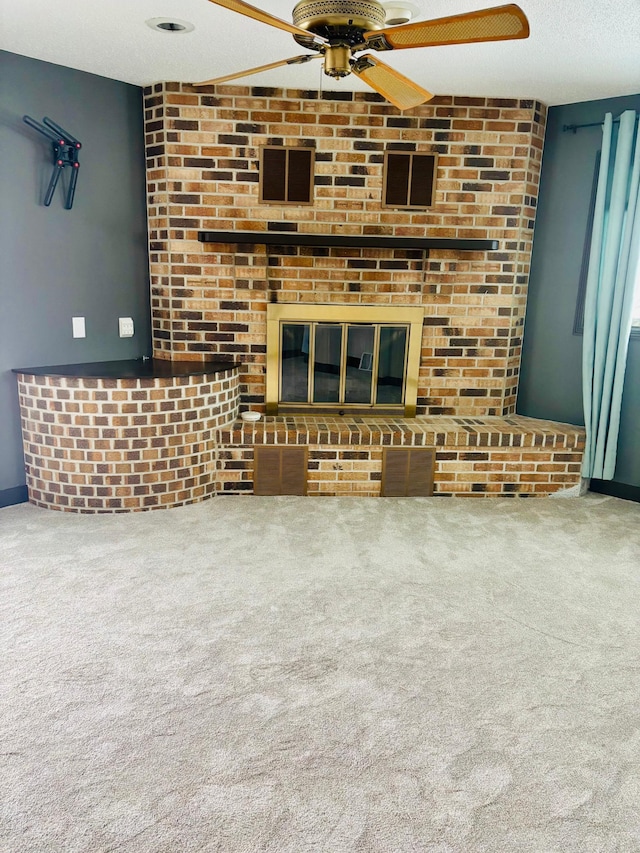 unfurnished living room featuring ceiling fan, a textured ceiling, and carpet