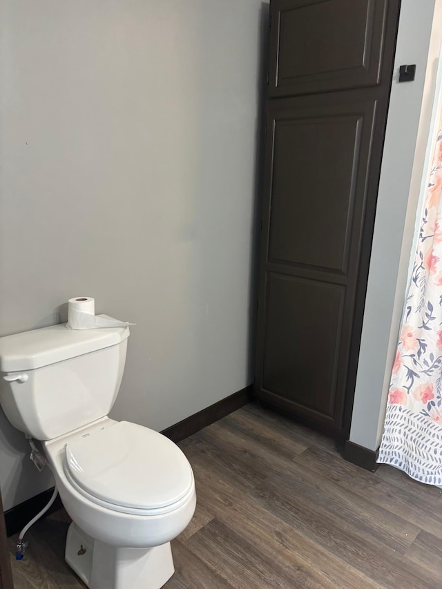 bathroom featuring wood-type flooring and toilet