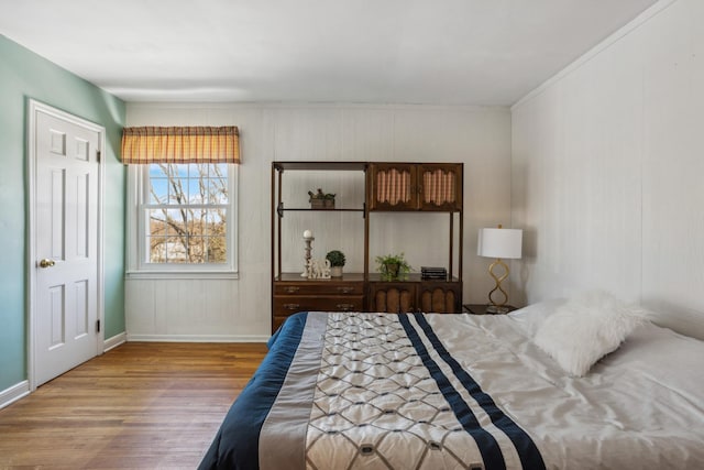 bedroom with baseboards and wood finished floors