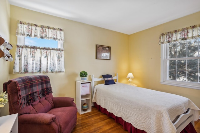 bedroom featuring multiple windows and dark wood-style flooring