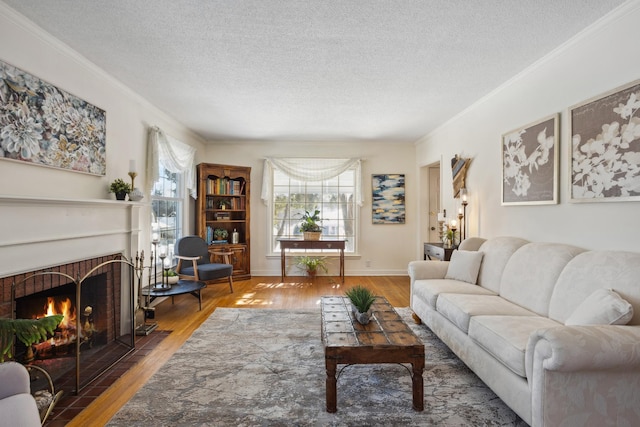 living room with a brick fireplace, crown molding, a textured ceiling, and wood finished floors