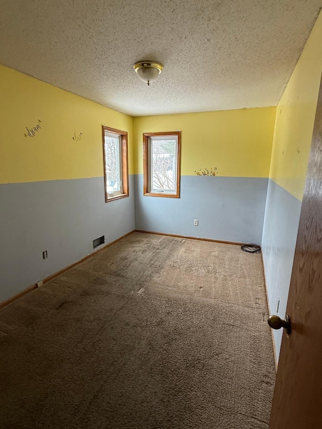 carpeted spare room featuring a textured ceiling