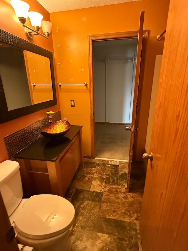 bathroom featuring vanity, an inviting chandelier, and toilet