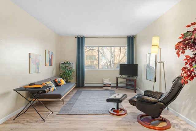 living area featuring a baseboard heating unit and light wood-type flooring