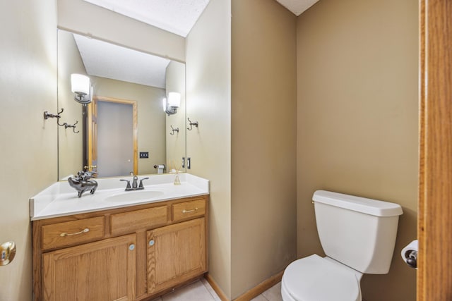 bathroom featuring tile patterned flooring, toilet, and vanity