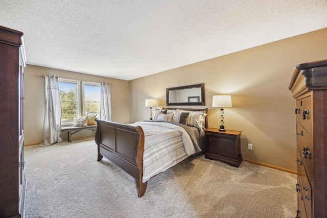 bedroom with baseboards, a textured ceiling, and light colored carpet