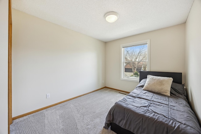 carpeted bedroom with baseboards and a textured ceiling