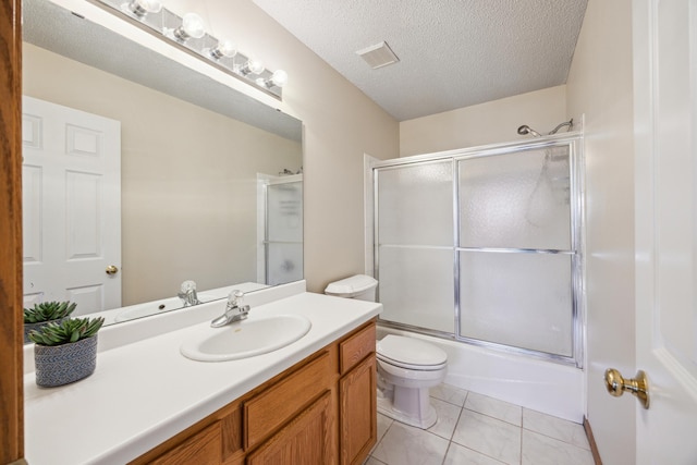 bathroom featuring a textured ceiling, shower / bath combination with glass door, toilet, visible vents, and vanity