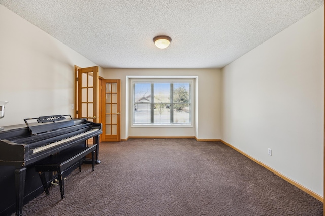 sitting room featuring a textured ceiling, carpet flooring, and baseboards