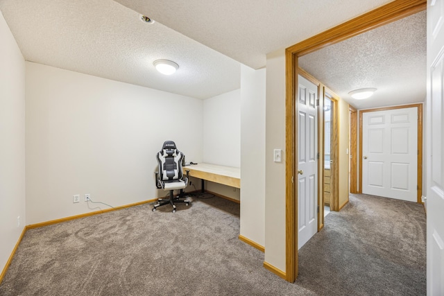 interior space featuring carpet floors, a textured ceiling, and baseboards