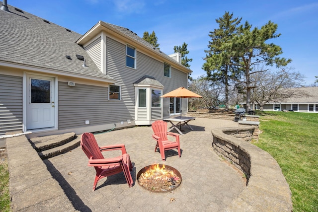 back of house featuring a chimney, a shingled roof, a yard, a patio area, and an outdoor fire pit