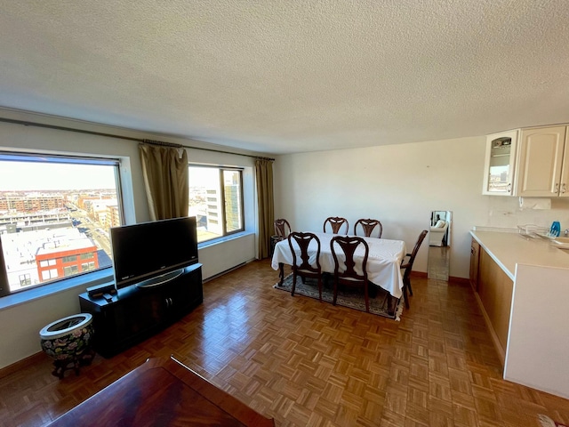 dining area featuring a textured ceiling and baseboards