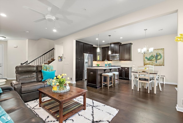 living room featuring sink, ceiling fan with notable chandelier, and dark hardwood / wood-style flooring