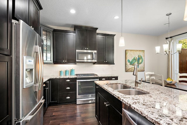 kitchen with sink, tasteful backsplash, decorative light fixtures, dark hardwood / wood-style flooring, and stainless steel appliances