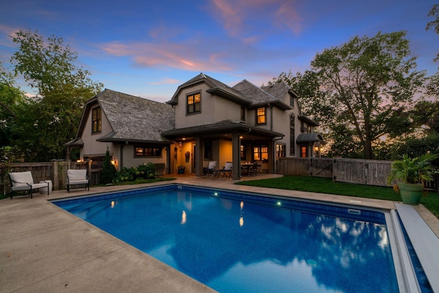 pool at dusk featuring a patio area