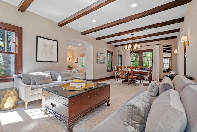 living room featuring light colored carpet, a chandelier, and beamed ceiling