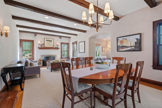 dining area featuring beamed ceiling, a chandelier, and a wealth of natural light