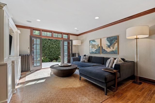 living room with wood-type flooring, ornamental molding, and radiator