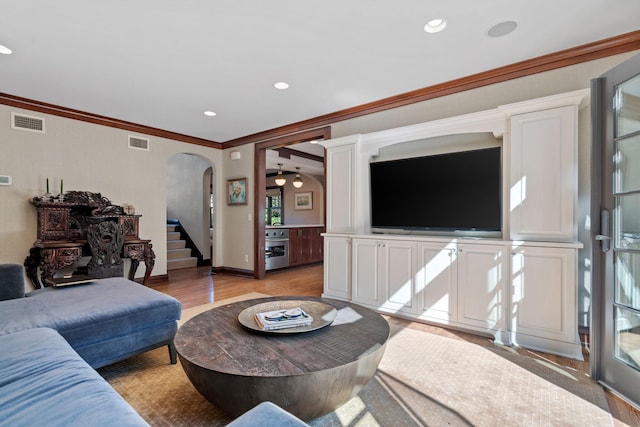 living room featuring crown molding and light wood-type flooring