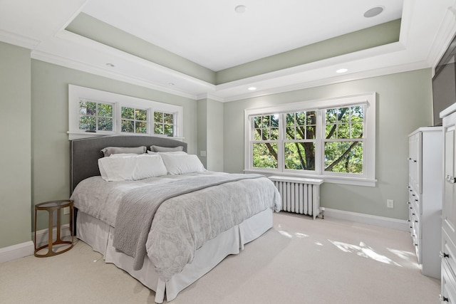 bedroom with crown molding, radiator, light carpet, and a raised ceiling