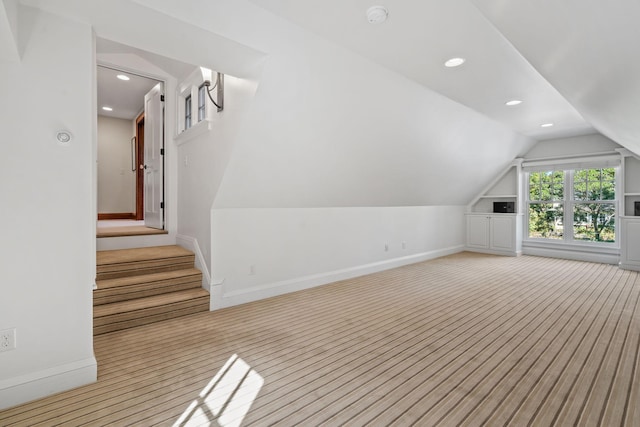 bonus room with lofted ceiling and light hardwood / wood-style floors