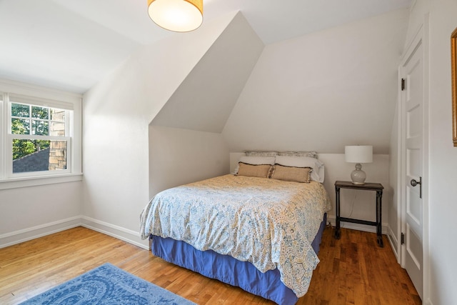 bedroom featuring wood-type flooring and vaulted ceiling