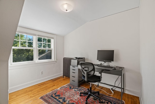 office featuring radiator heating unit, vaulted ceiling, and hardwood / wood-style floors