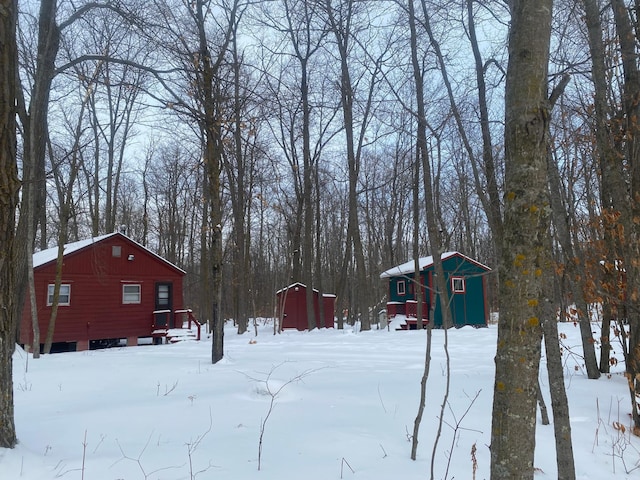 yard layered in snow with a shed