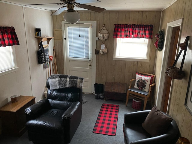 interior space with ceiling fan, carpet, and wooden walls