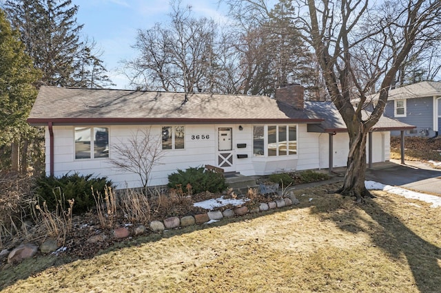 single story home with a shingled roof, driveway, a chimney, and an attached garage