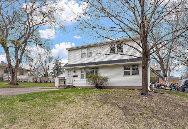 traditional-style house featuring fence and a front lawn