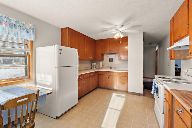 kitchen with ceiling fan, white appliances, light countertops, brown cabinetry, and under cabinet range hood