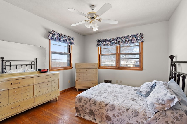 bedroom featuring baseboards, a ceiling fan, and hardwood / wood-style flooring