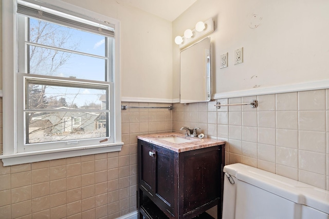 half bath with vanity, toilet, and tile walls