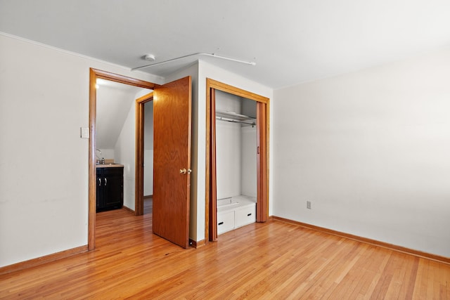 unfurnished bedroom featuring a closet, baseboards, and light wood-type flooring